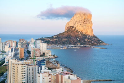 Ifach rock with cloud hat overlooks the city of calpe, costa blanca, spain. 