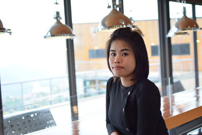 Portrait of beautiful young woman sitting in cafe