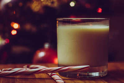 Close-up of drink by candy canes in glass on table