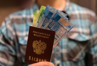 Midsection of man holding money and passport