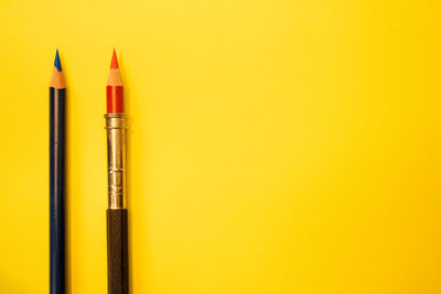 Close-up of pen against yellow background