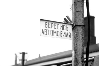 Low angle view of road sign against clear sky