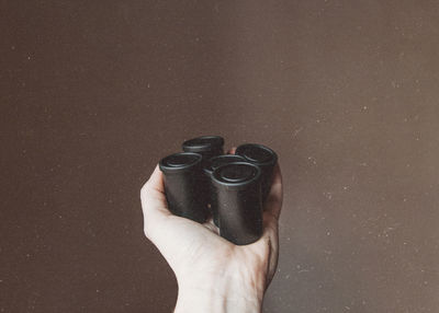 Close-up of hand holding film reel against wall