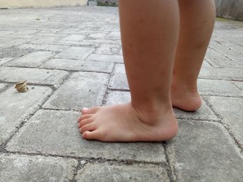 Low section of baby feet on footpath