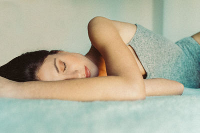 Portrait of young woman sleeping on bed