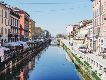 Canal amidst buildings against sky in city