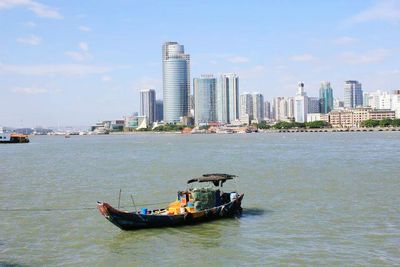 Boats in sea with city in background