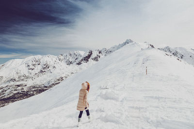 Woman walking on snow covered landscape