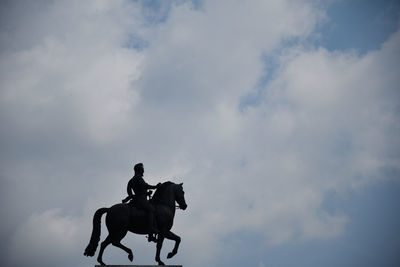 Horse riding motorcycle against sky