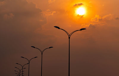 Low angle view of street light against orange sky