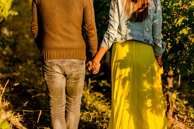 Midsection of couple standing by plants