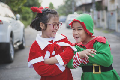 Asian girl and boy wearing santa claus suit playing with happiness outdoor