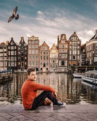 Portrait of man sitting by canal