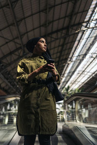 Portrait of young woman standing in city