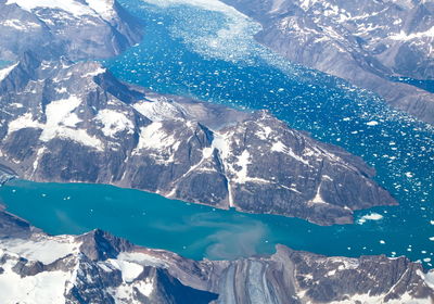 Scenic view of sea by snowcapped mountain