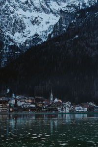 River by buildings in city during winter