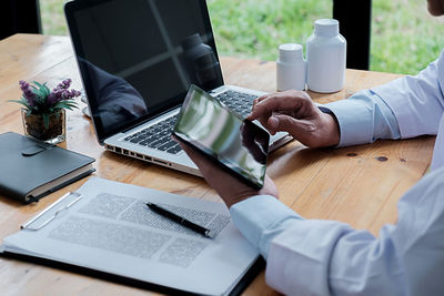 Midsection of man using laptop on table