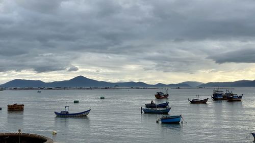 Boats moored in sea against sky