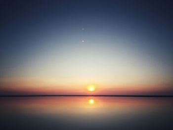 Scenic view of sea against clear sky during sunset