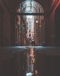 Reflection of illuminated buildings on wet street at night