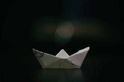 Close-up of paper boat over black background