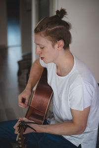 Dreamy look of a young blond singer with freckles sitting in the middle of a lighted room