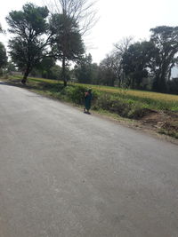 Rear view of man riding bicycle on road