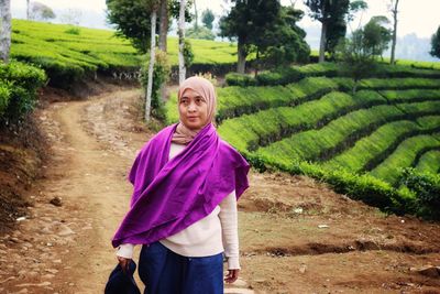 Portrait of young woman standing on field