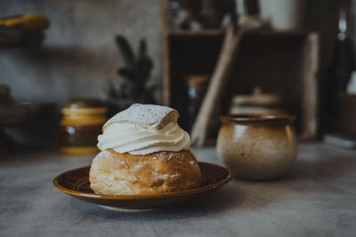 Bun with whipped cream on plate