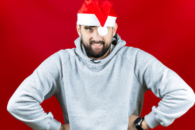 Portrait of man wearing hat against red background