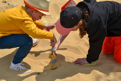 Boy and girl playing on the beach on summer holidays. children building a sandcastle at the sea.