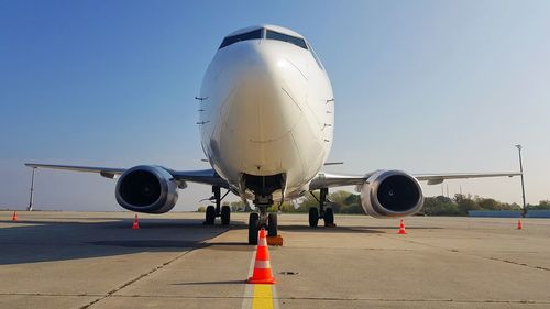 Airplane on airport runway against clear blue sky