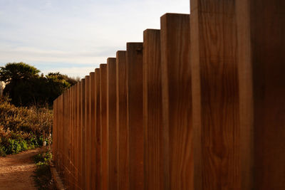 Panoramic shot of wooden fence on landscape against sky