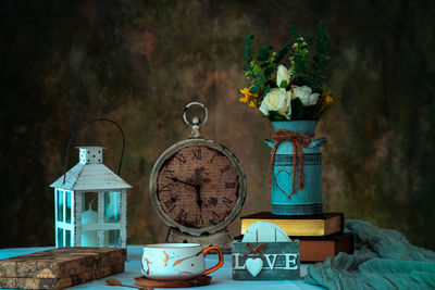 Close-up of flower vase on table against wall