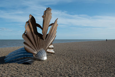 Sculpture on beach against sky