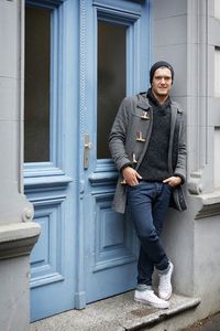 Portrait of smiling man standing on door