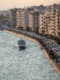 Boats sailing on sea by buildings in city