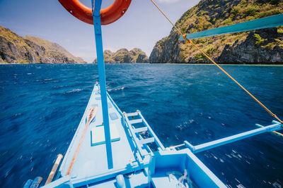 Sailboat sailing in sea against blue sky