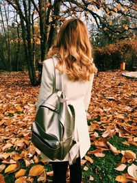 Rear view of woman standing by tree in park