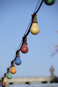 Low angle view of illuminated light bulb against sky