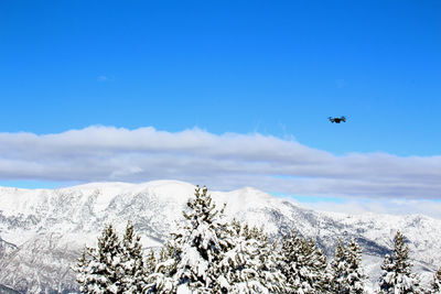 Low angle view of snow covered mountain against blue sky