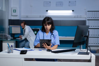 Nurse using digital tablet in clinic