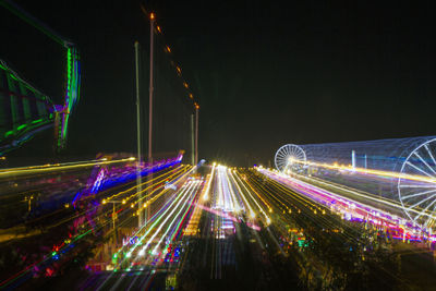 Light trails on road against sky at night