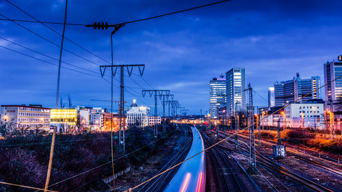 Railroad tracks against sky at night