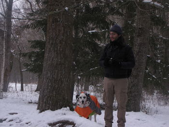 Portrait of smiling woman with dog on snow