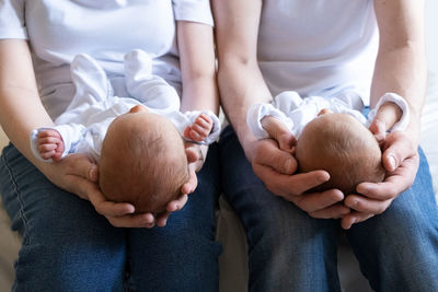 Newborn identical twins on the bed, on a parents hands. life style, emotions of kids. infant babies 