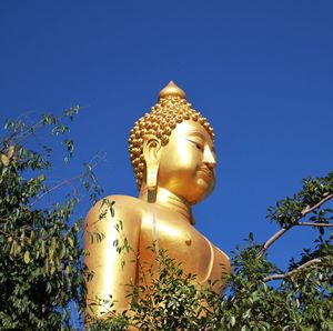 Low angle view of statue against clear blue sky