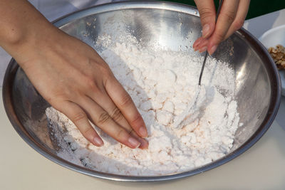 Close-up of chef mixing flour in bowl on table
