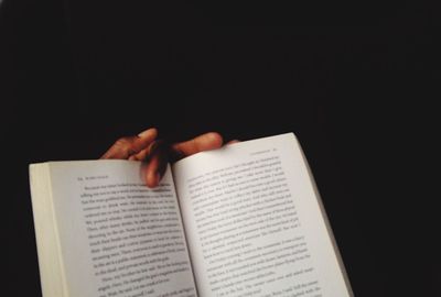 Close-up of cropped hand holding book