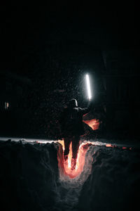 Silhouette man standing on street at night